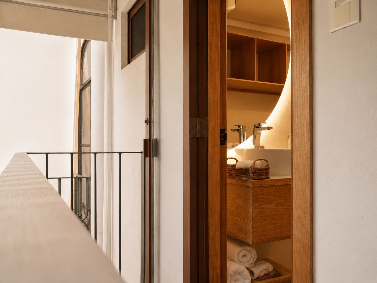 A hotel room with a wooden vanity, a sink, and a window.