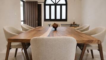 A dining area with a long wooden table and four upholstered chairs.