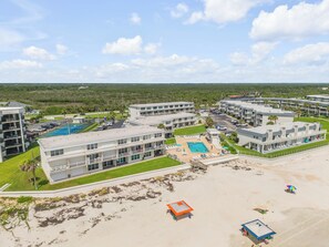 Um resort com vários edifícios, uma piscina e uma área de praia.