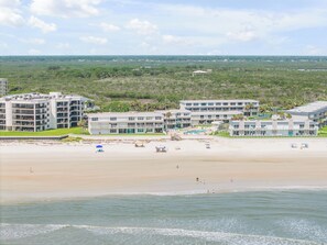 A beachfront hotel with multiple floors, a swimming pool, and a beach area. - New Listing! Updated Oceanview 2/2 | Beachfront Pool & Beach Access (New Smyrna Beach)