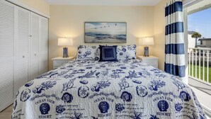 Una camera da letto con un letto, due lampade da comodino, un quadro e vista sull'esterno.