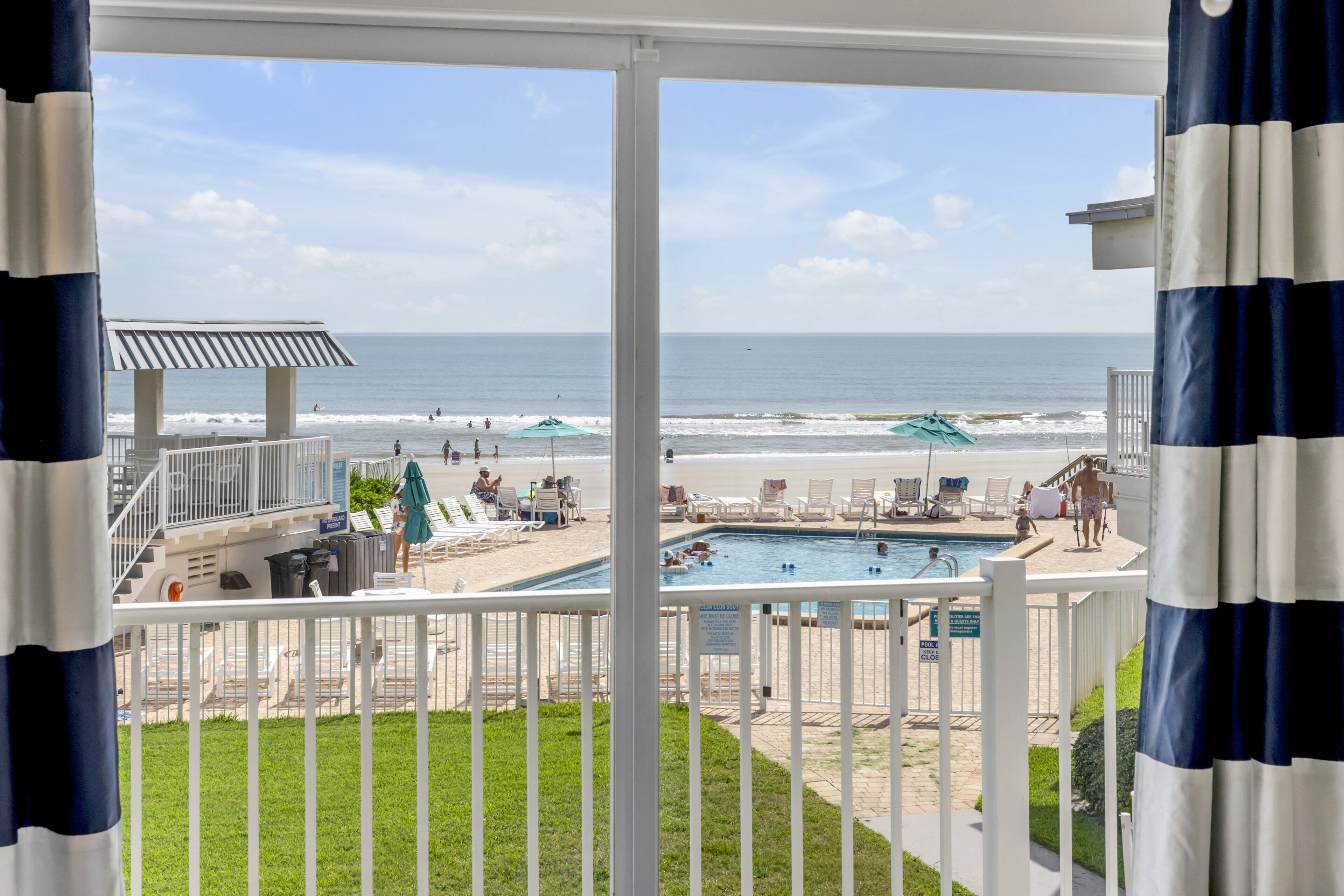 Ein Poolbereich mit Blick auf Strand und Meer.