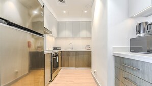 A modern kitchen with a stainless steel range hood, wooden cabinets, and a built-in oven.