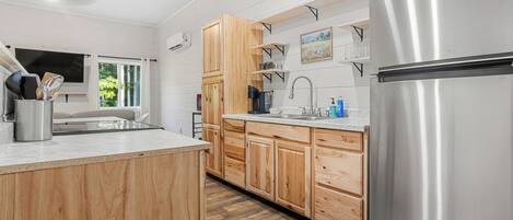 A modern kitchen with wooden cabinets, a stainless steel refrigerator, and a built-in sink.
