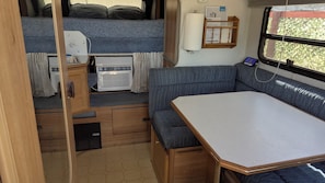 A compact RV interior with a bed, kitchenette, and seating area. - Mountain bungalow in serene Tijeras.  20 min. to downtown ABQ, 35 to Santa Fe (Tijeras)