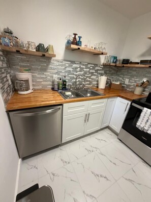 A kitchen with a coffee maker, sink, and cabinets. - “No pasa nada” (Pompano Beach)