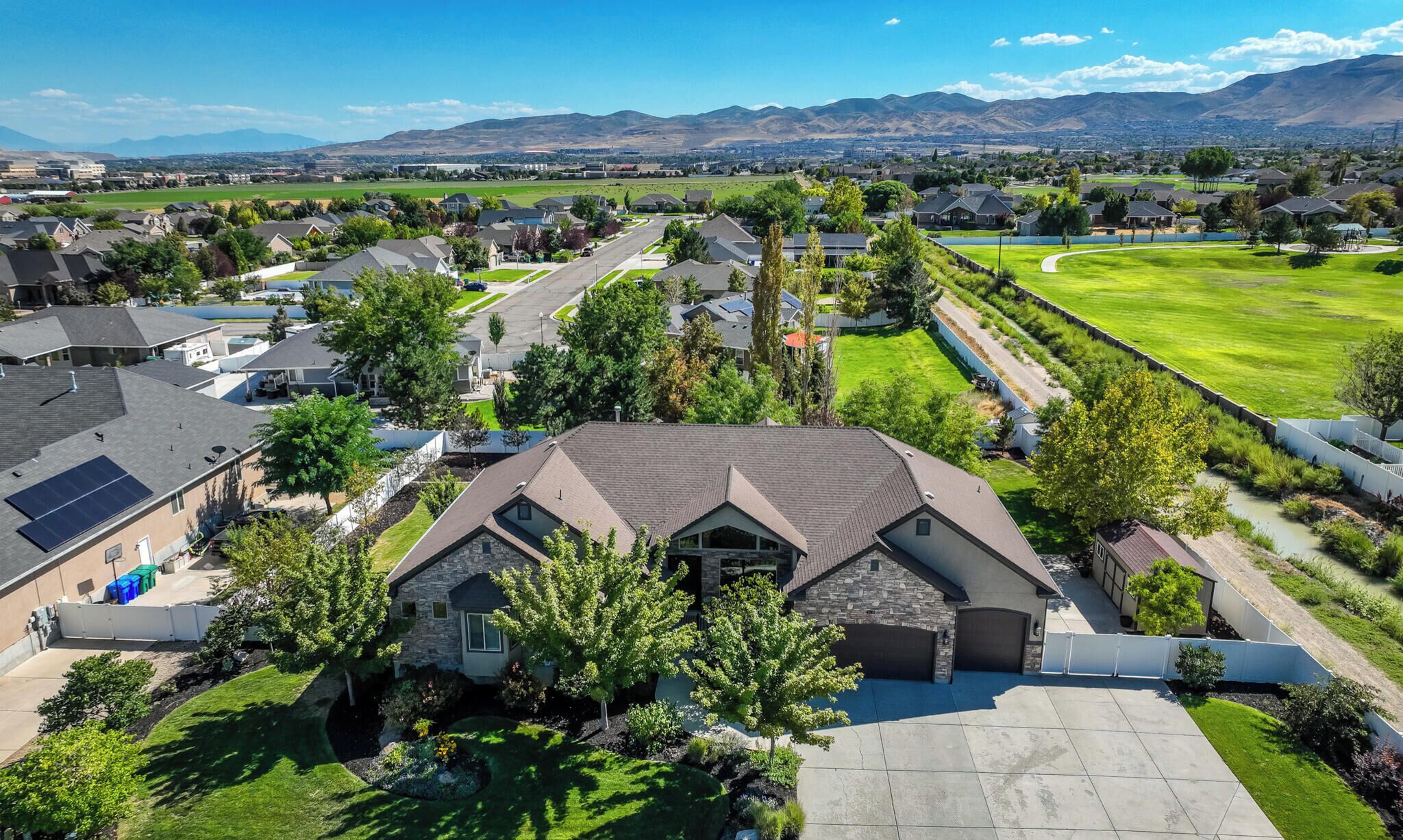 A residential area with houses, a well-maintained lawn, and a clear view of distant mountains.