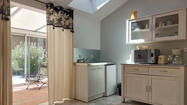 A kitchen with a microwave, toaster, and cabinets. - Charmante maison proche plage (Châtelaillon-Plage)
