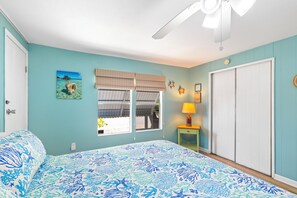 A bedroom with a bed, a window with a view, a ceiling fan, and a door. - Waterfront Escape - Canal Front, 50ft Dock, King Beds and Pet Friendly (Little Torch Key)