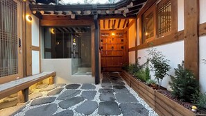 A traditional Japanese-style entrance with a stone pathway leading to a wooden door.