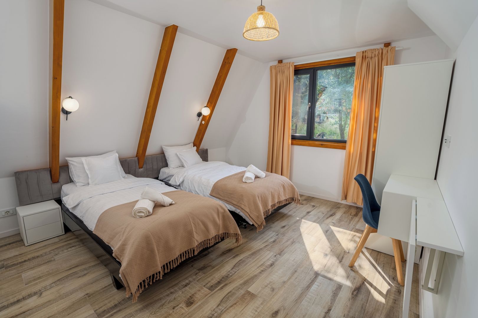 Un dormitorio moderno con dos camas, un escritorio y una ventana con cortinas.