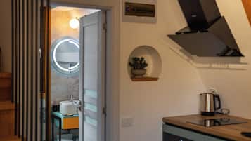 Una cocina moderna con horno empotrado, cafetera y microondas.