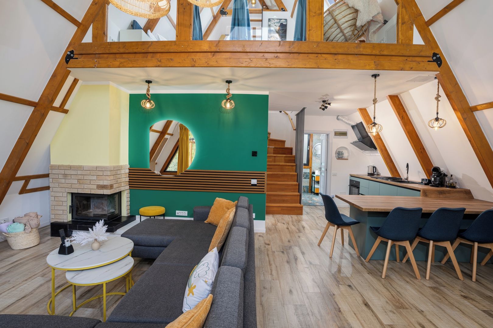 Un interior con diseño estilo loft, que incluye una chimenea, una zona de comedor con sillas y un sofá.