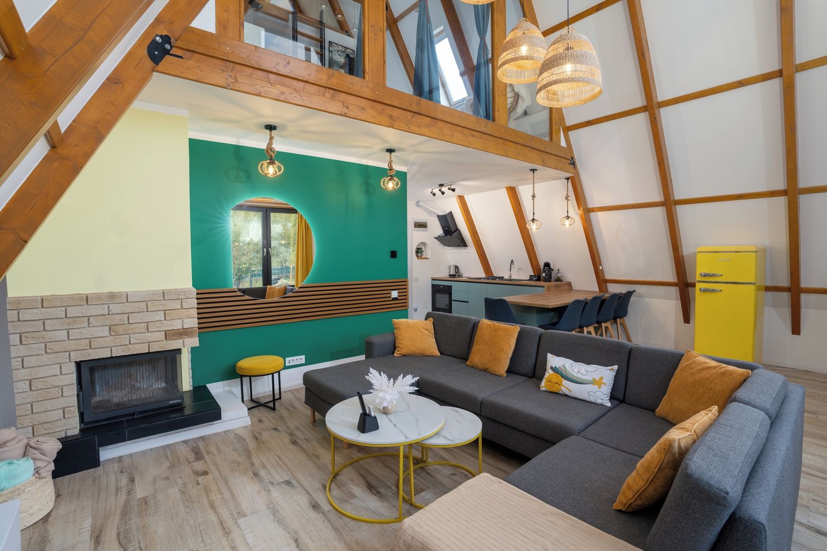 Een moderne woonkamer met een open haard, een bank, een eethoek en een keuken.