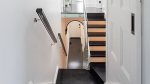 Ein schmaler Korridor mit einer Treppe, die zu einer Zwischenebene führt.