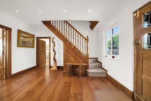 A wooden staircase with a handrail, leading to a landing with a bench and a door. - Berry Lodge I 5 Bed House Sleeps 10 -Hot Tub -Spa (Upminster)