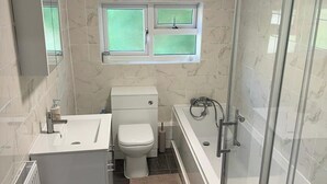 Une salle de bain avec des toilettes, un lavabo et une douche.