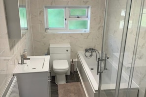 A bathroom with a toilet, sink, and shower.