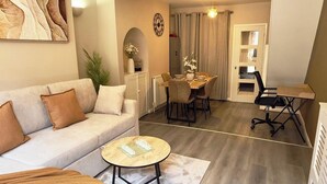 Un salon comprenant un canapé, une table basse et un coin repas avec des chaises et une table.