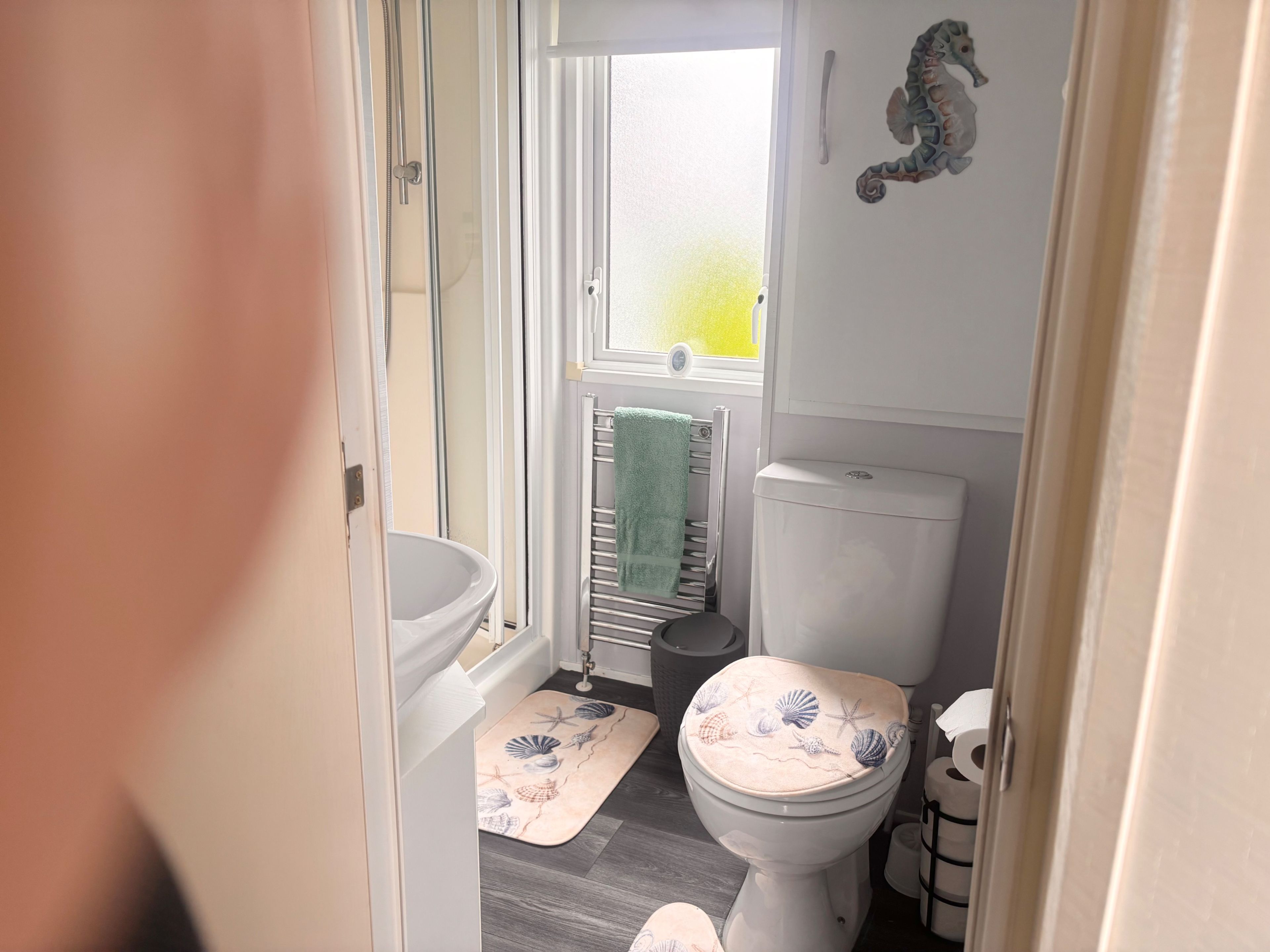 Une salle de bain avec des toilettes, une douche et une fenêtre.