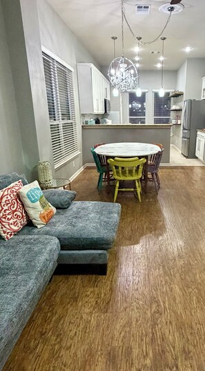 A modern kitchen with a dining area, wooden flooring, and a chandelier. - The Witte Estate - 5BR Main House + Apartment (Kyle)