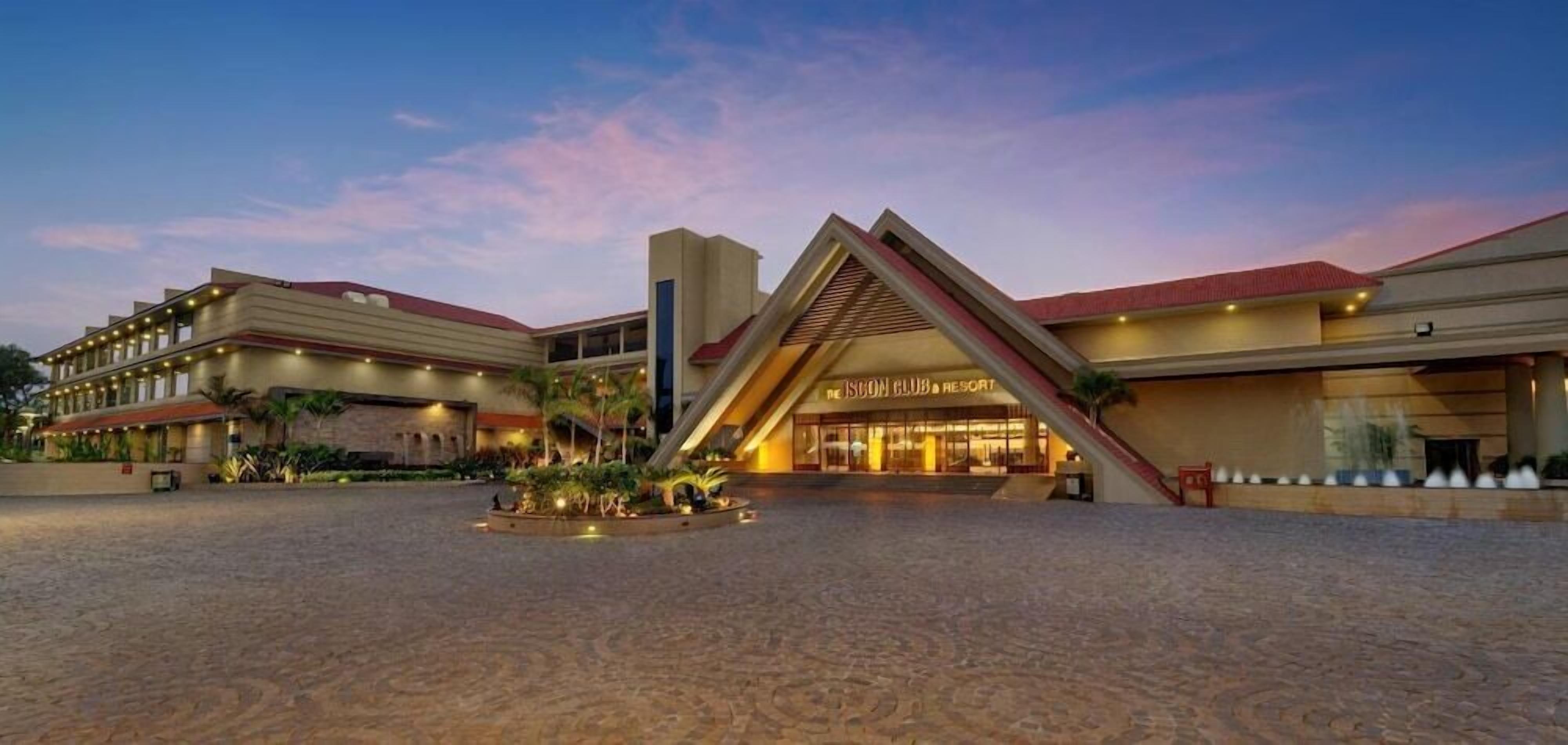 A hotel with a prominent entrance, a covered outdoor area, and a well-lit facade.