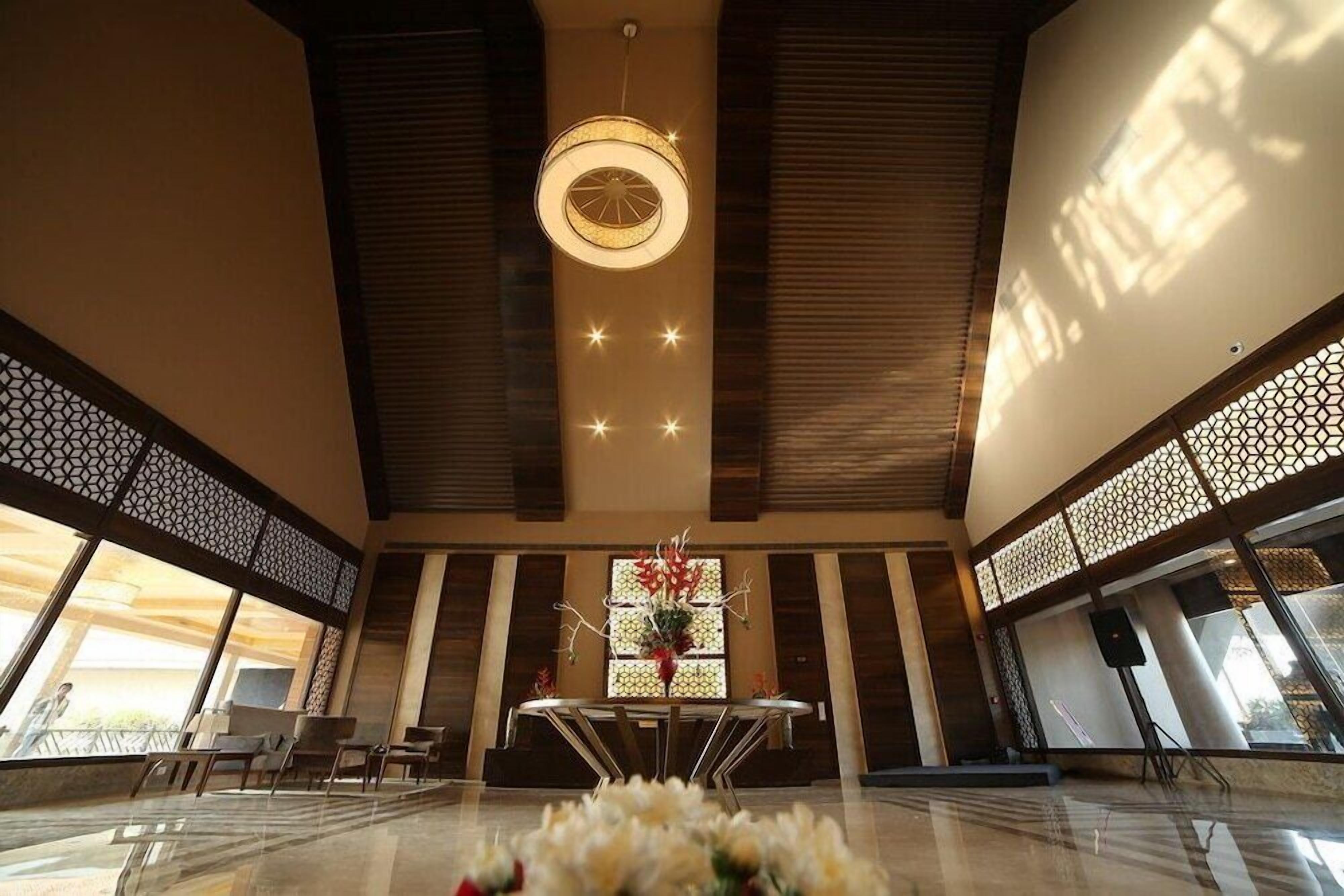 A spacious lobby with a central table, seating area, and a decorative light fixture.