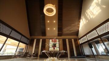 A spacious lobby with a central table, seating area, and a decorative light fixture.