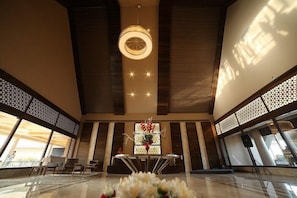 A spacious lobby with a central table, seating area, and a decorative light fixture.