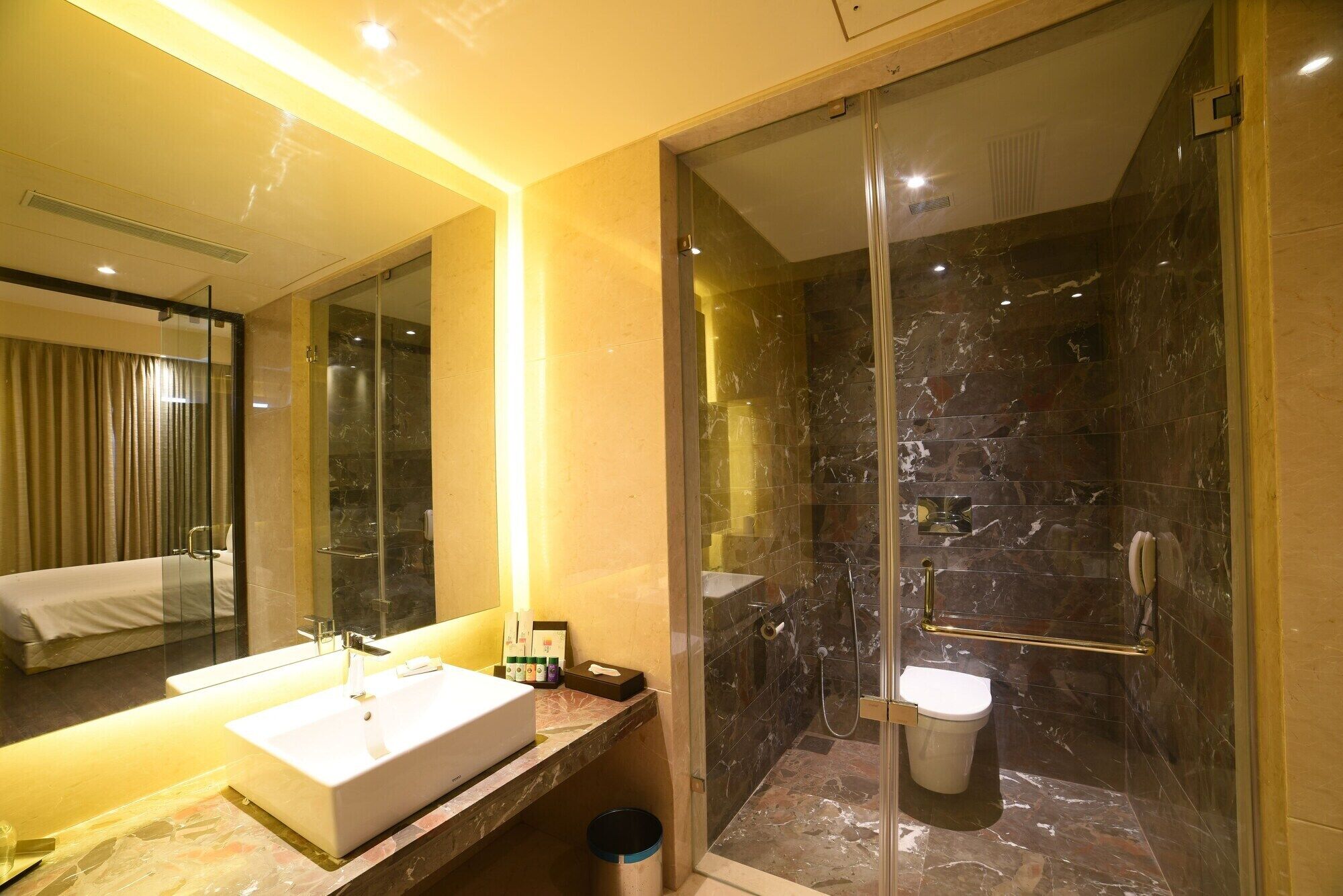 A modern bathroom with a glass-enclosed shower, a sink, and a toilet.