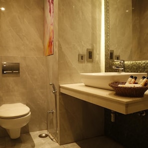 Ein modernes Badezimmer mit Toilette, Dusche und Waschbecken mit Spiegel darüber.