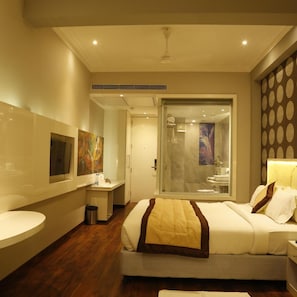 Ein modernes Hotelzimmer mit Bett, Nachttisch und Duschbereich.