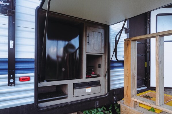 A compact, enclosed space with a window, a small cabinet, and a power outlet.