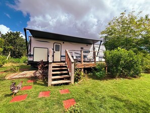 Une maison mobile dotée d’un porche et d’une rampe menant à l’entrée.