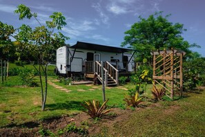 A mobile home with a porch and steps leading to a deck.