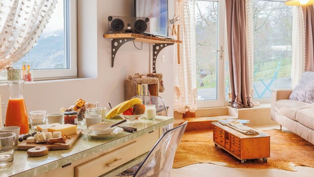 En hyggelig opholdsstue med et tekøkken, en sofa og udsigt til det fri.