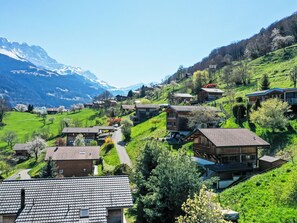 A hillside village with traditional houses, a winding road, and a mountain backdrop. - Lau'tentik by Interhome (Collombey-Muraz)