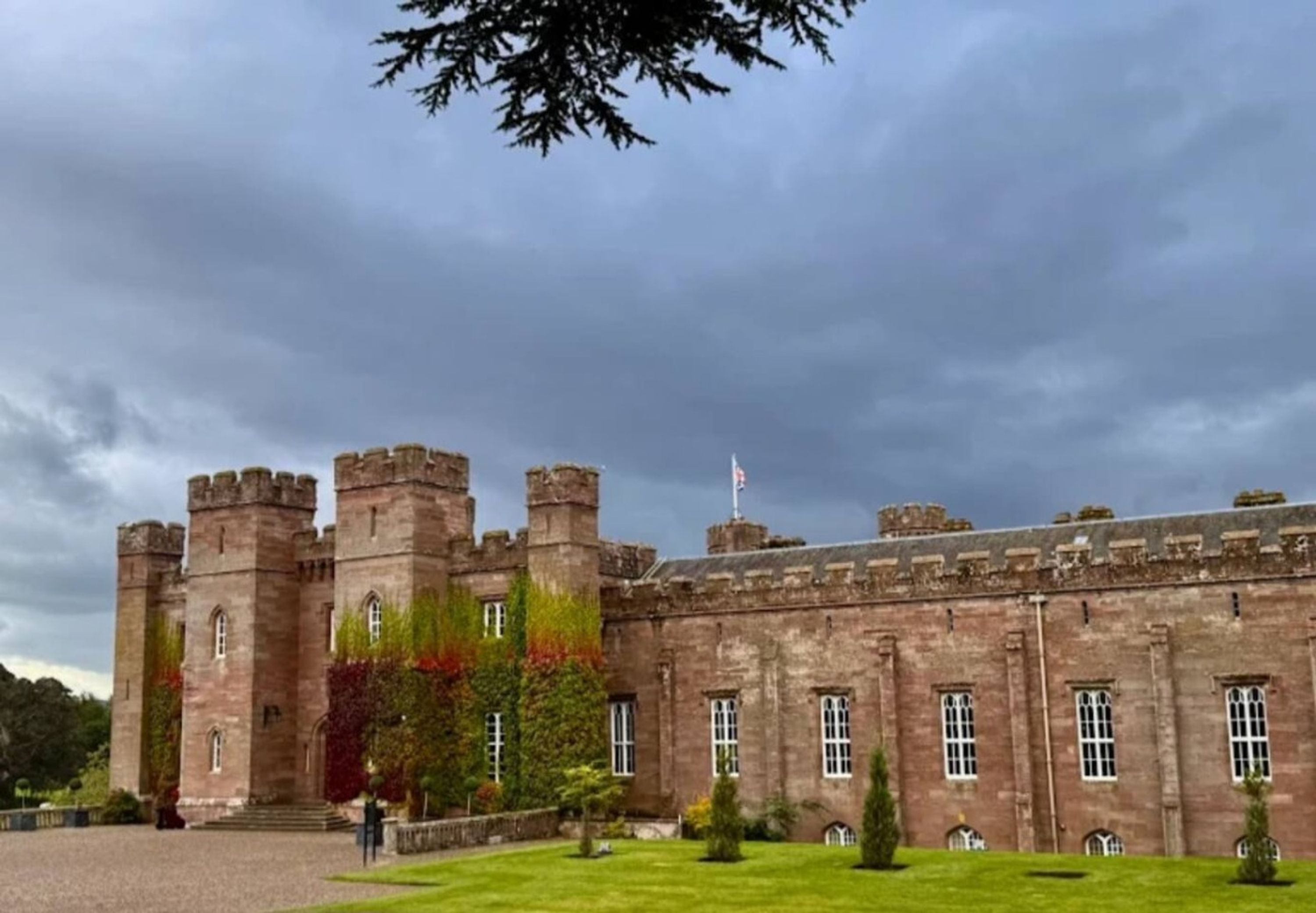 A historic castle with multiple towers and a flag.
