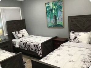 Ein Schlafzimmer mit einem Bett, zwei Nachttischen, einer Lampe und einem Bild an der Wand.