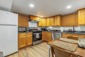 A modern kitchen with wooden cabinets, a stainless steel refrigerator, a built-in oven, and a microwave. - Cozy Garden apart. 1-bedroom in Franklin Park, near O'Hare and ,,METRO"station (Franklin Park)