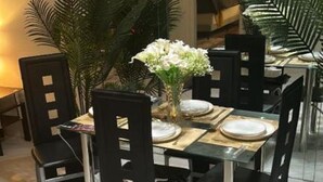 A dining area with a glass table, black chairs, and a chandelier. - CONDO IN DELRAY BEACH (Delray Beach)