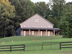 A large, single-story barn with a gabled roof and a covered porch area.