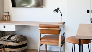 Um espaço de trabalho moderno com escrivaninha de madeira, cadeira de couro e luminária fixada.
