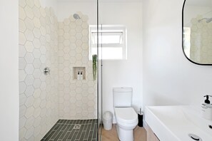 Ein Badezimmer mit Dusche, Toilette und Waschbecken.