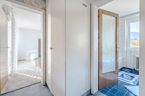 A hallway with a door leading to a bedroom, a bathroom with a shower, and a view of the outdoors. - Villa Evita – Vintage House with Pool in Pohorje, Lovrenc na Pohorju, Slovenia (Lovrenc na Pohorju)