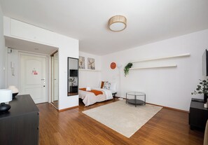 A modern hotel room with a bed, bedside table, and a small round table. - Rondo ONZ Homely Apartment (Warszawa)