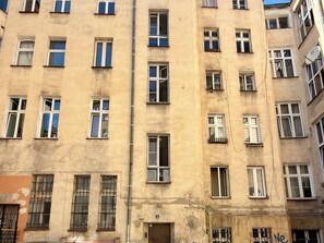 A multi-story building with numerous windows, some with shutters, and a visible door at the ground level. - Zelwerowicza Central Studio (Wrocław)