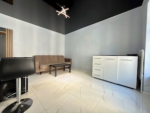 A modern living room with a sofa, a coffee table, a TV, and a white cabinet. - Zelwerowicza Central Studio (Wrocław)