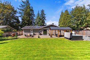 A residential property with a covered patio, solar panels, and a well-maintained lawn. - The Terrace | Grason Properties (Puyallup)