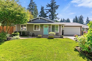 A single-story house with a front porch, a garage, and a well-maintained lawn.